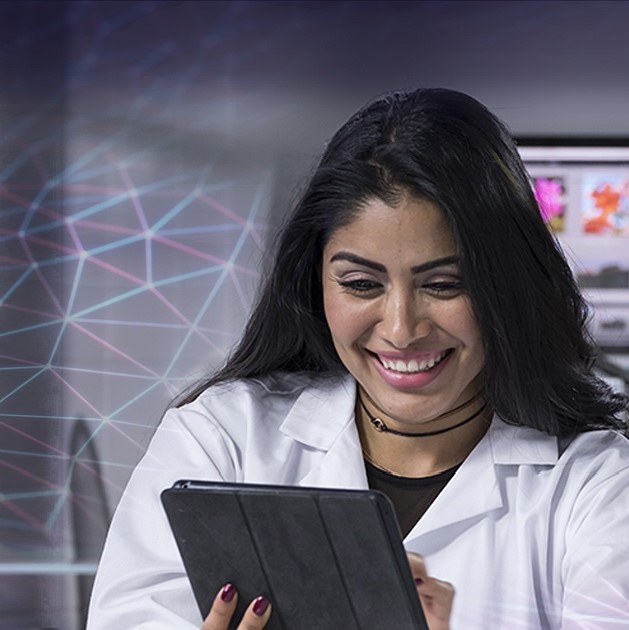 Smiling female scientist looking at a tablet.