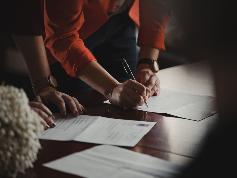 Woman signing document.